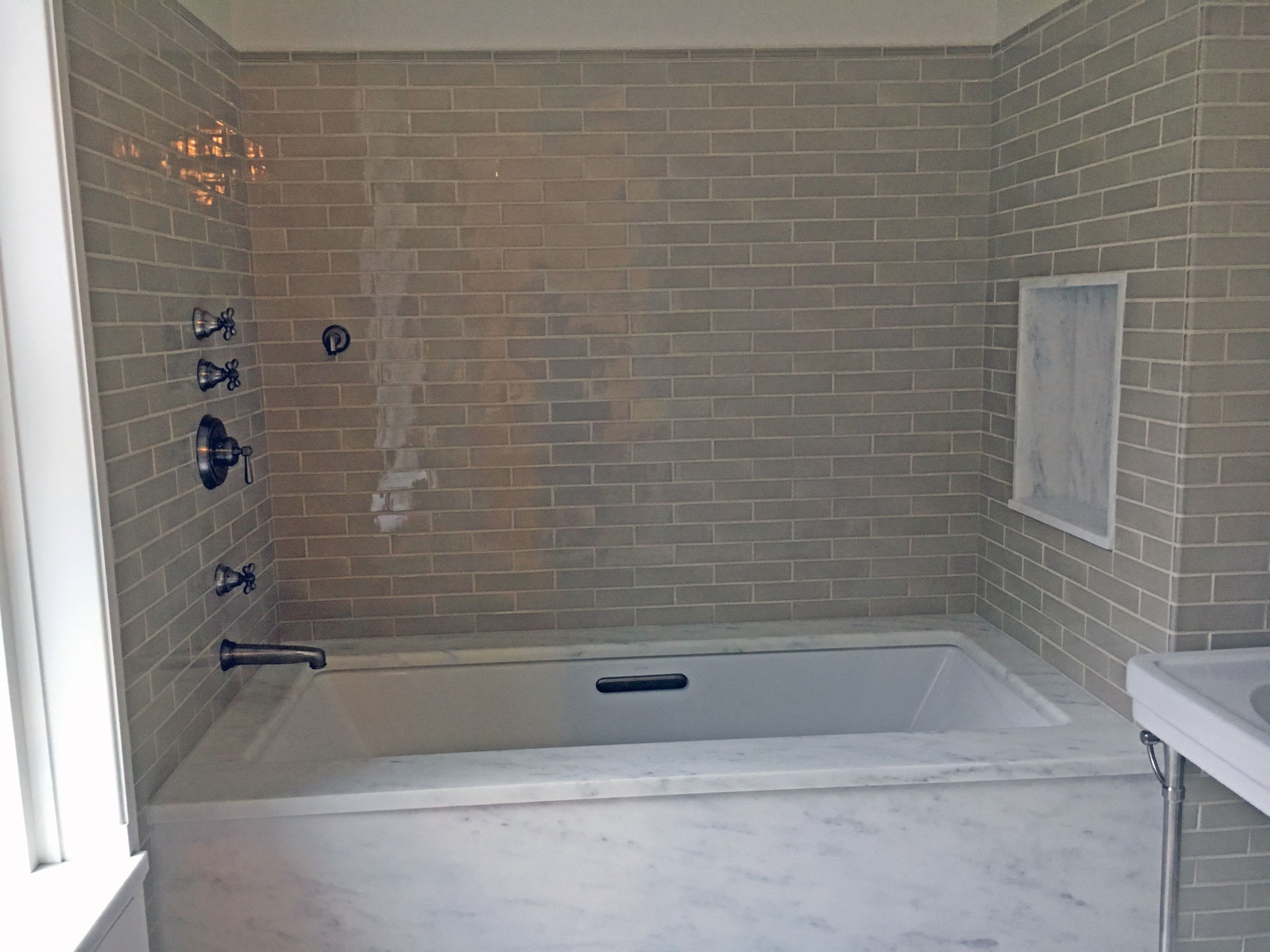Subway tiles and marble tub trim